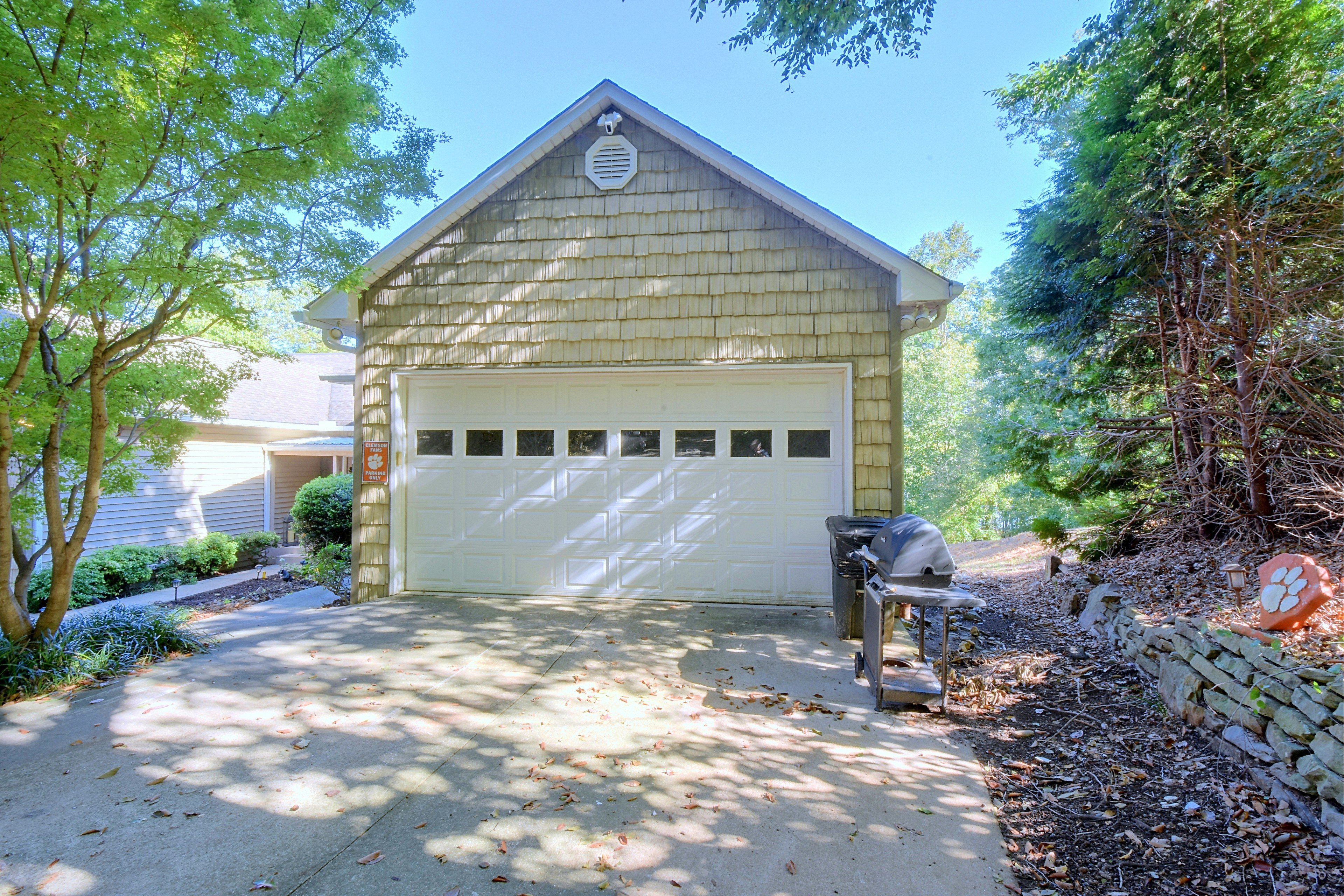 Detached garage exterior with parking sign and outdoor grill.