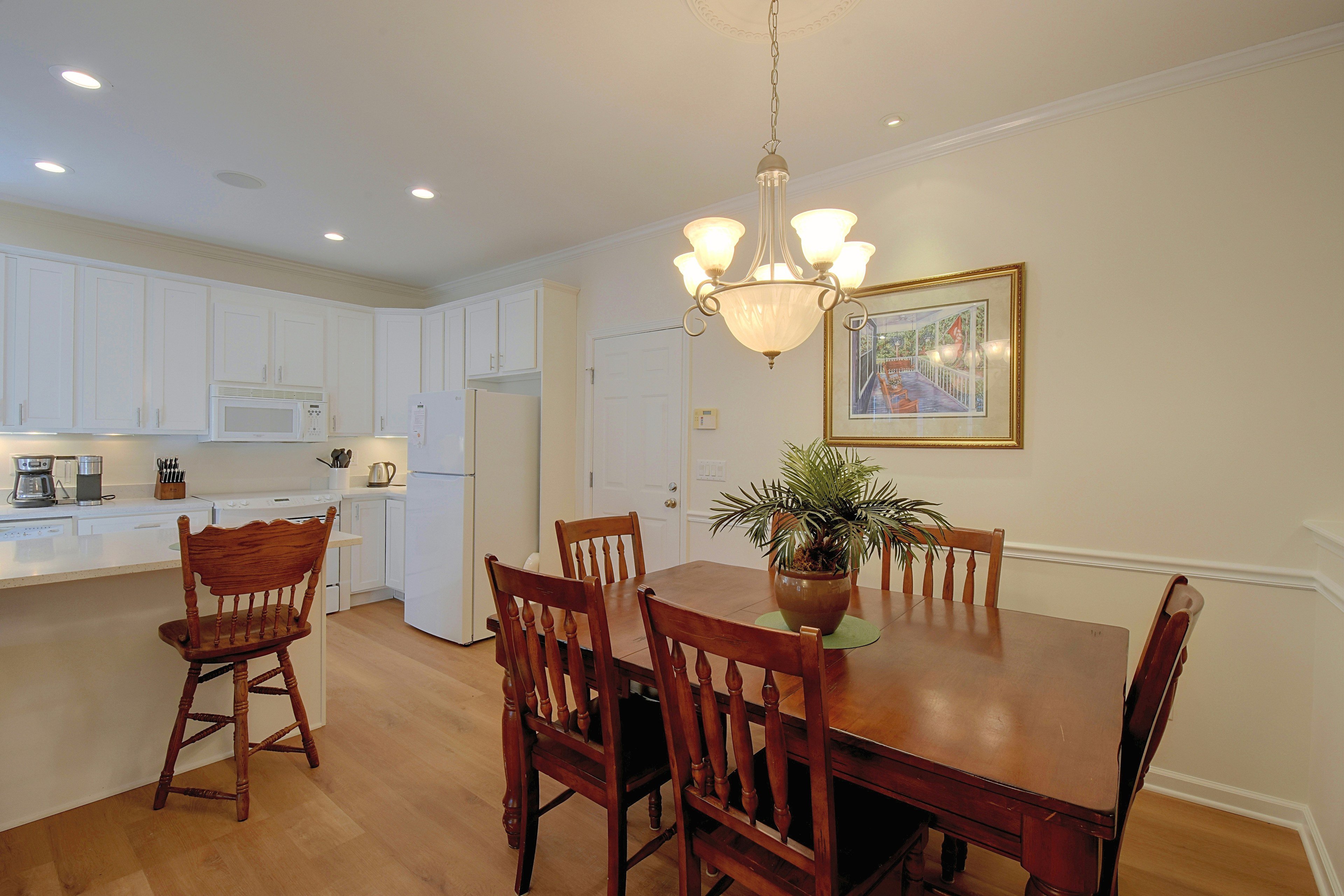 Dining area with wooden dining table adjacent to kitchen.