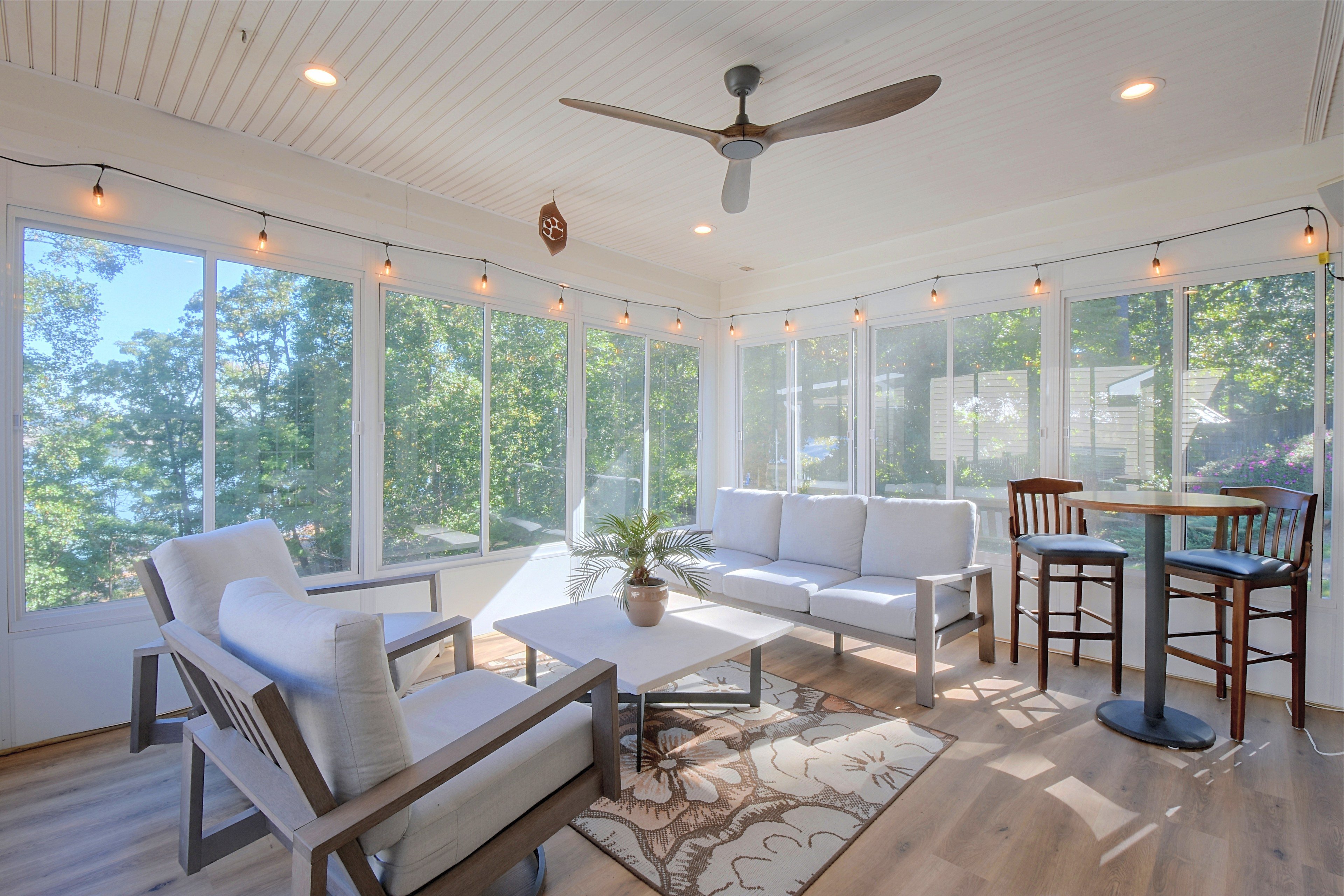 Sunroom view through large windows overlooking trees.