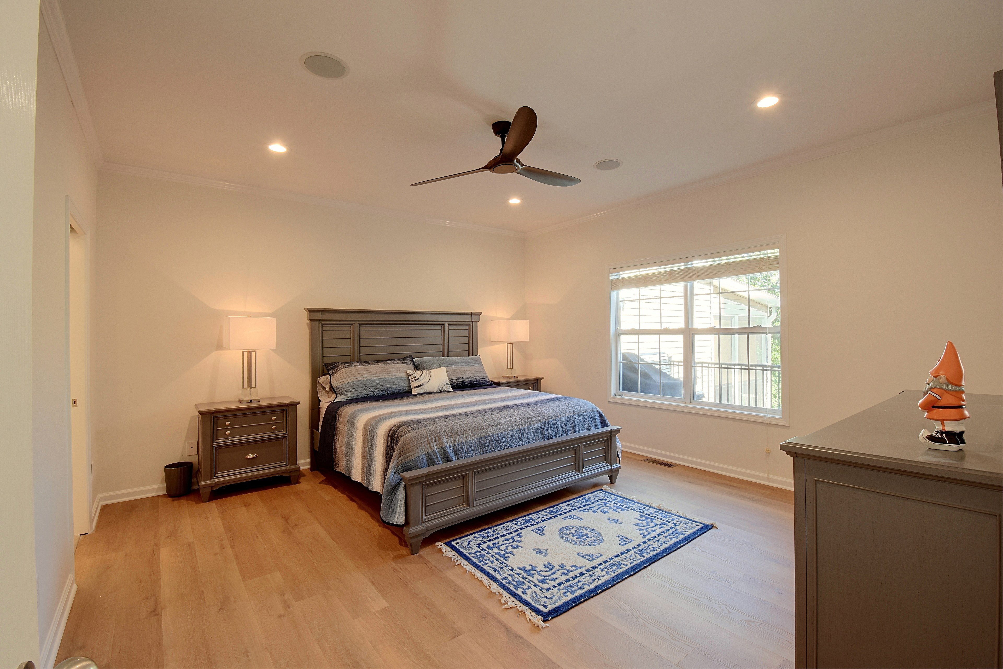 Primary bedroom furnished with a king-size bed, nightstands with lamps, and dresser.