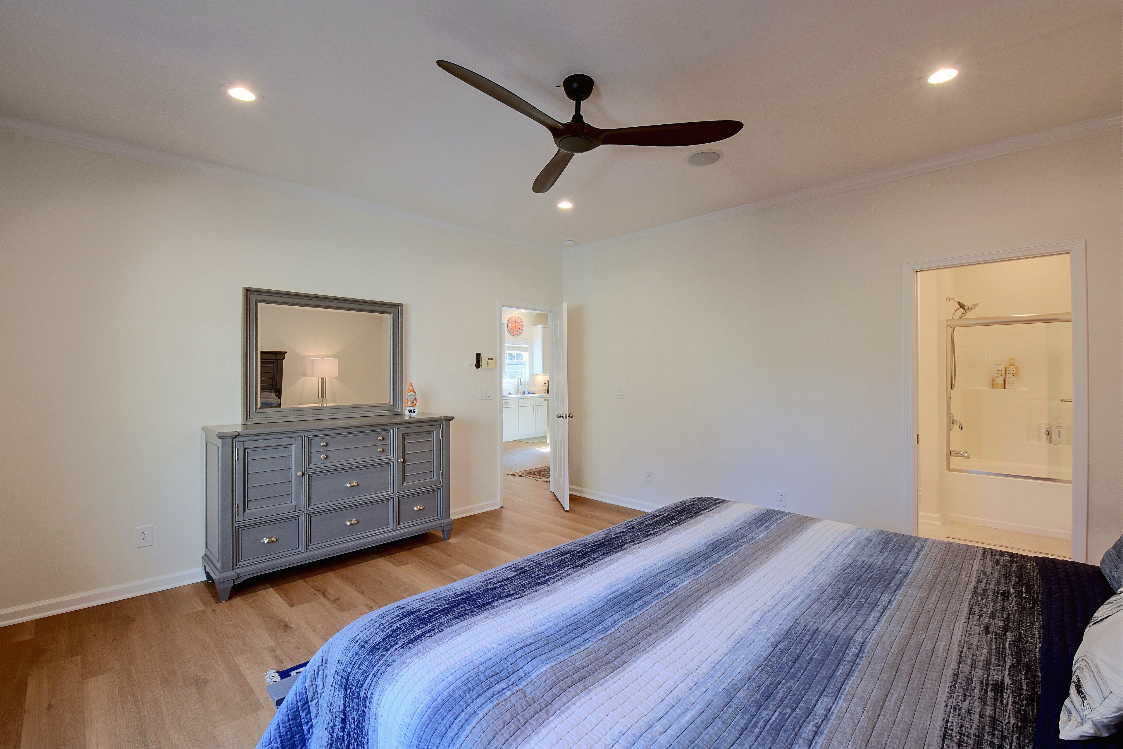 Primary bedroom view facing dresser and hallway door.