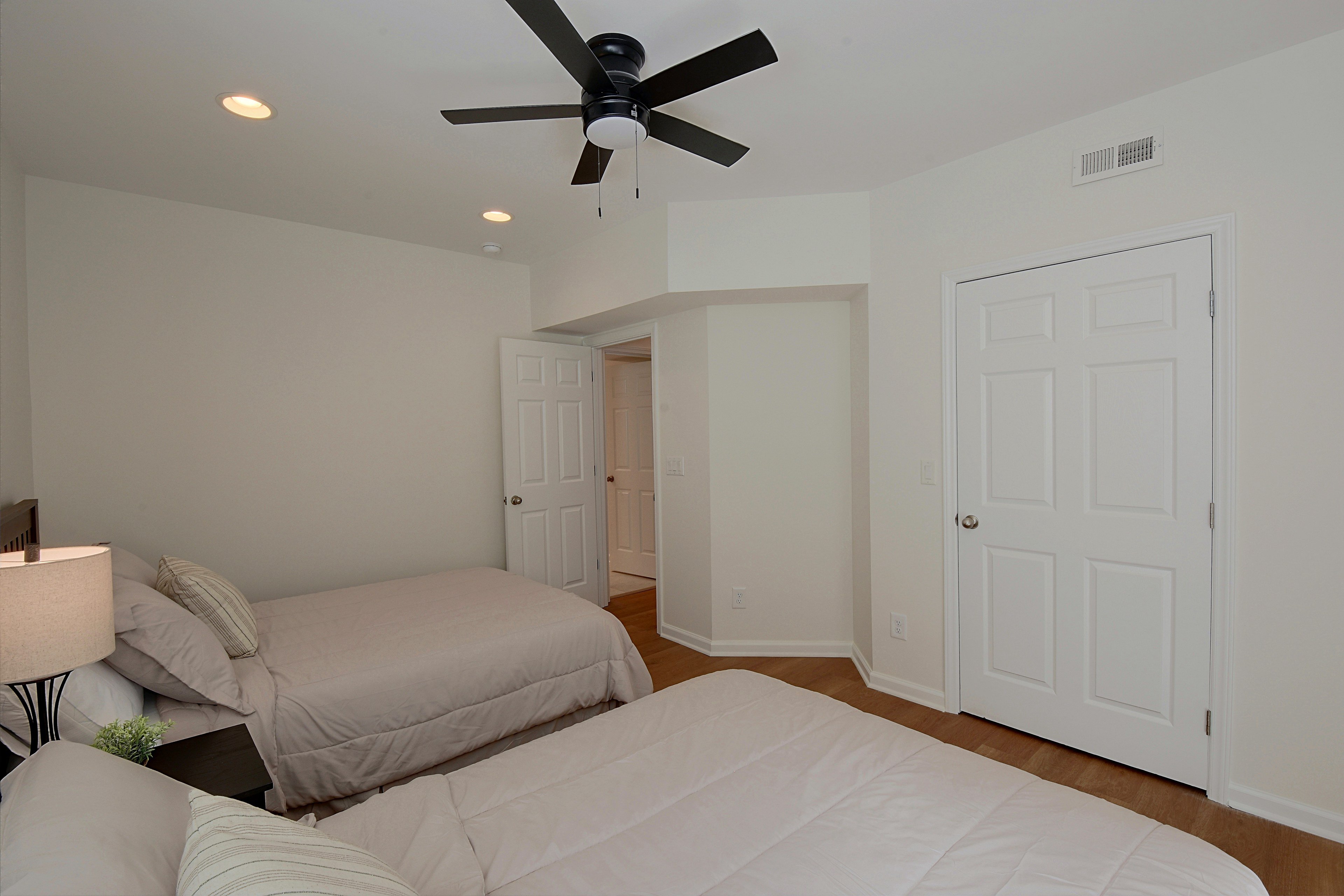 Third bedroom angle showing two beds and closet door.