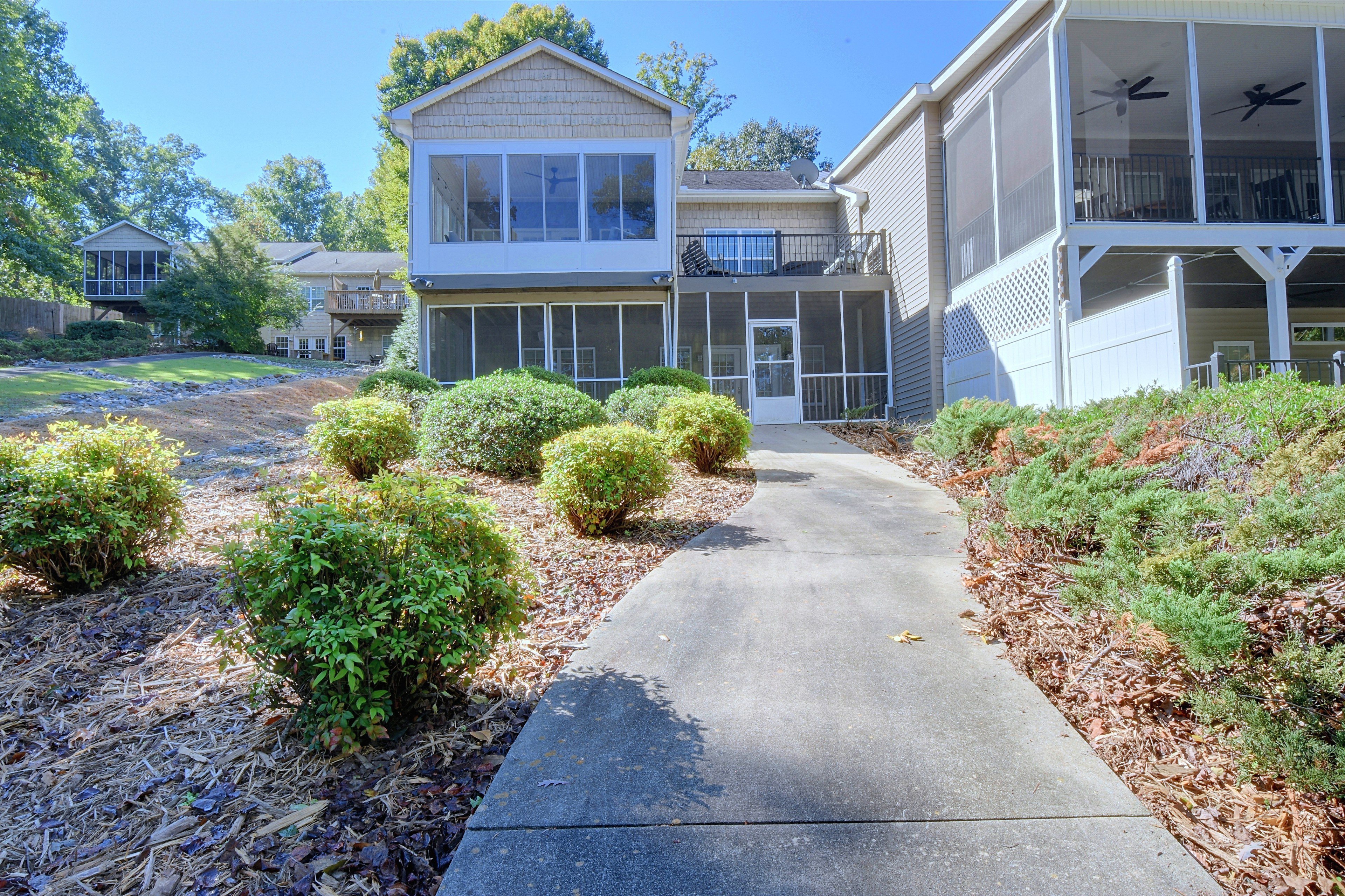 Rear exterior view of the multi-level home featuring the sunroom, deck, and lower screened porch.