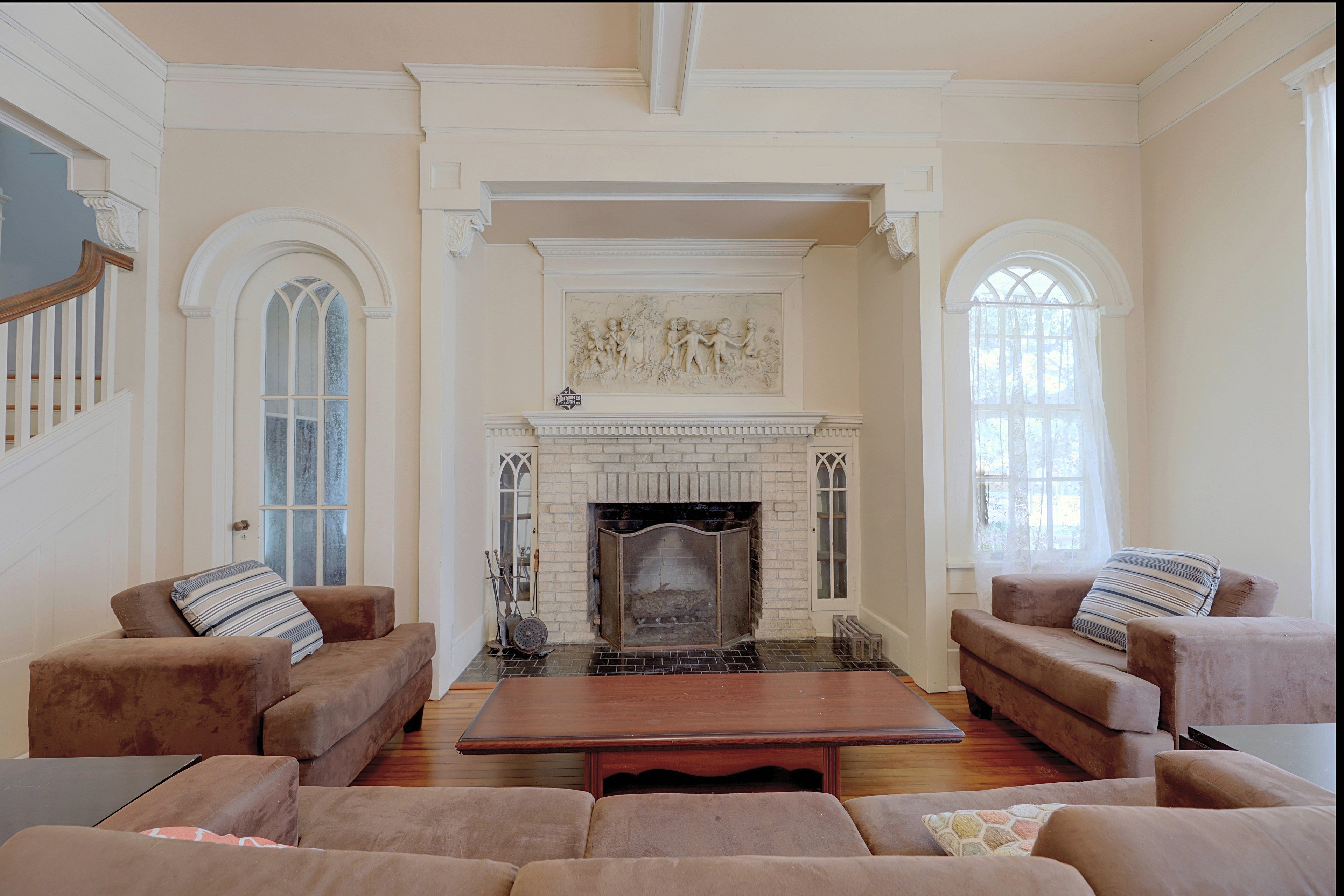 Focal view of the brick fireplace flanked by arched display alcoves in the main living space.
