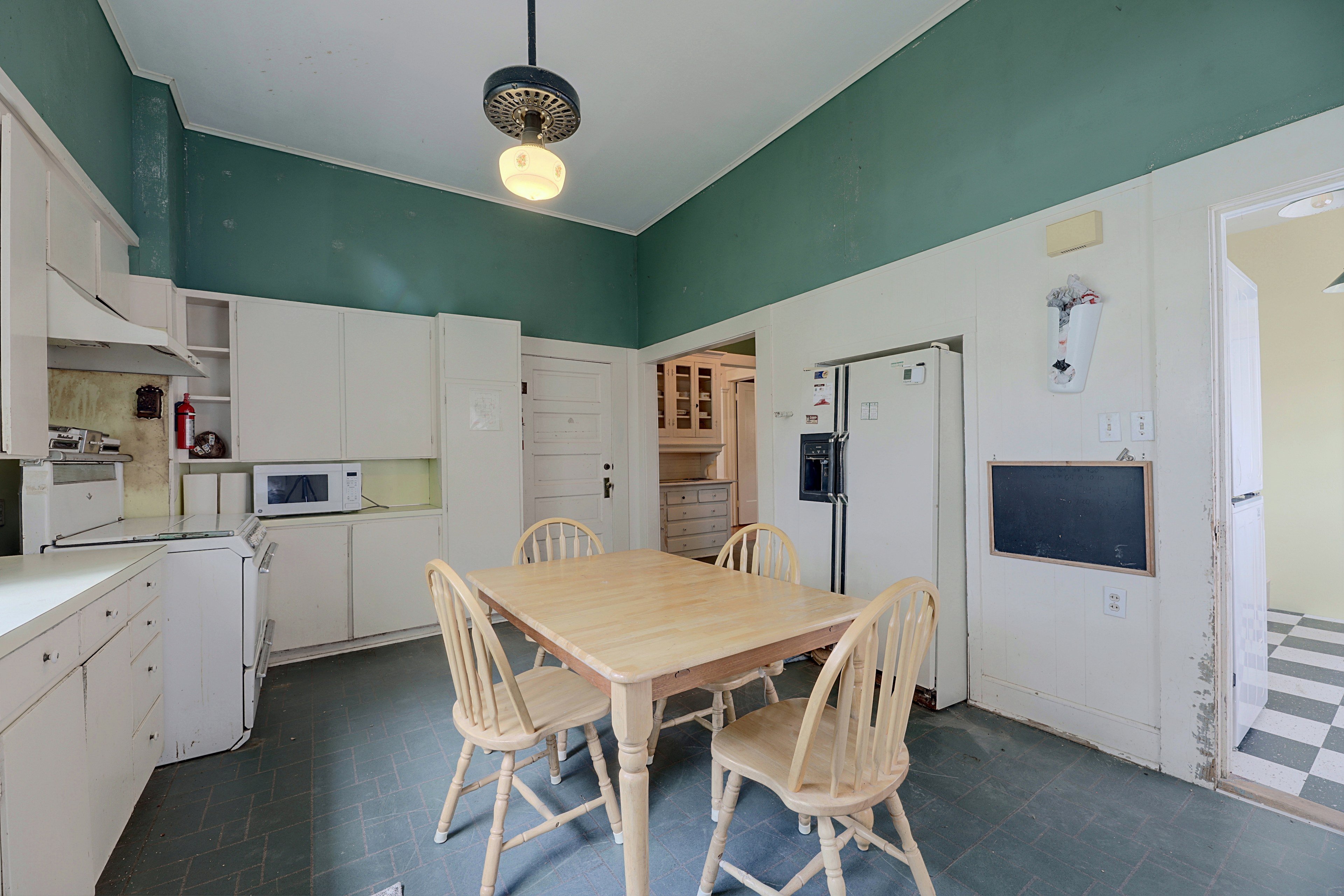 Alternate view of the kitchen equipped with full appliances and upper cabinet space.