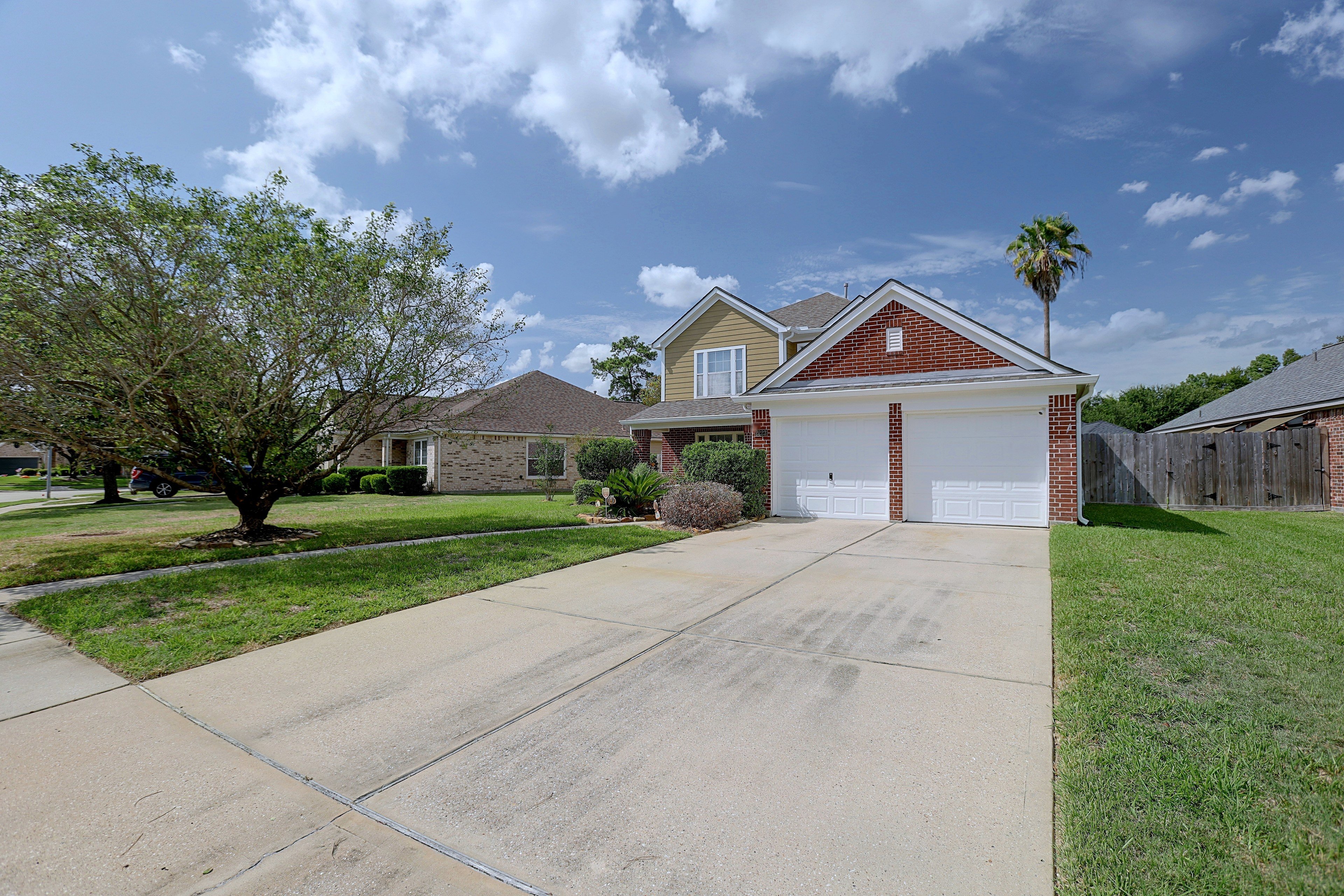 Front exterior view of the house, driveway, and front lawn.