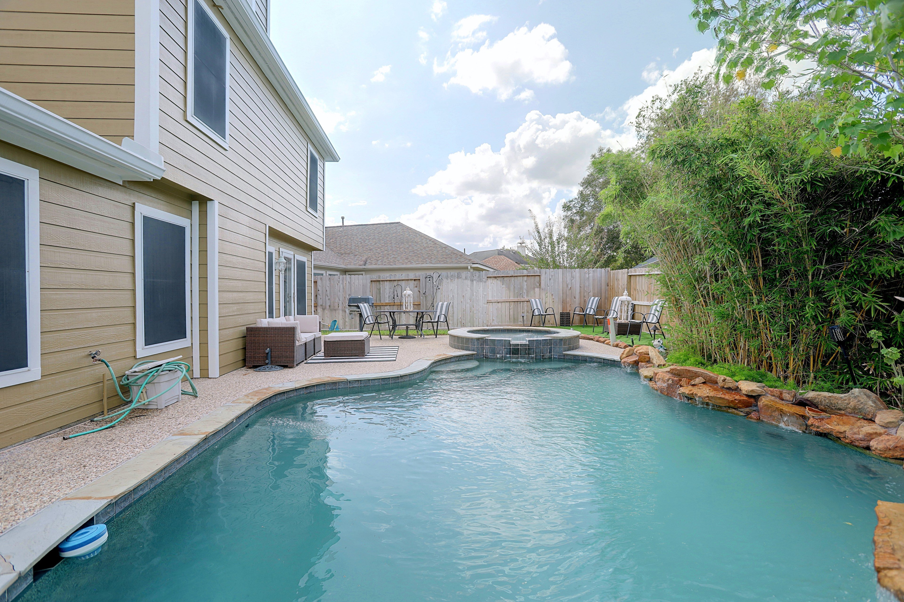 Side patio view along the home exterior next to the pool.