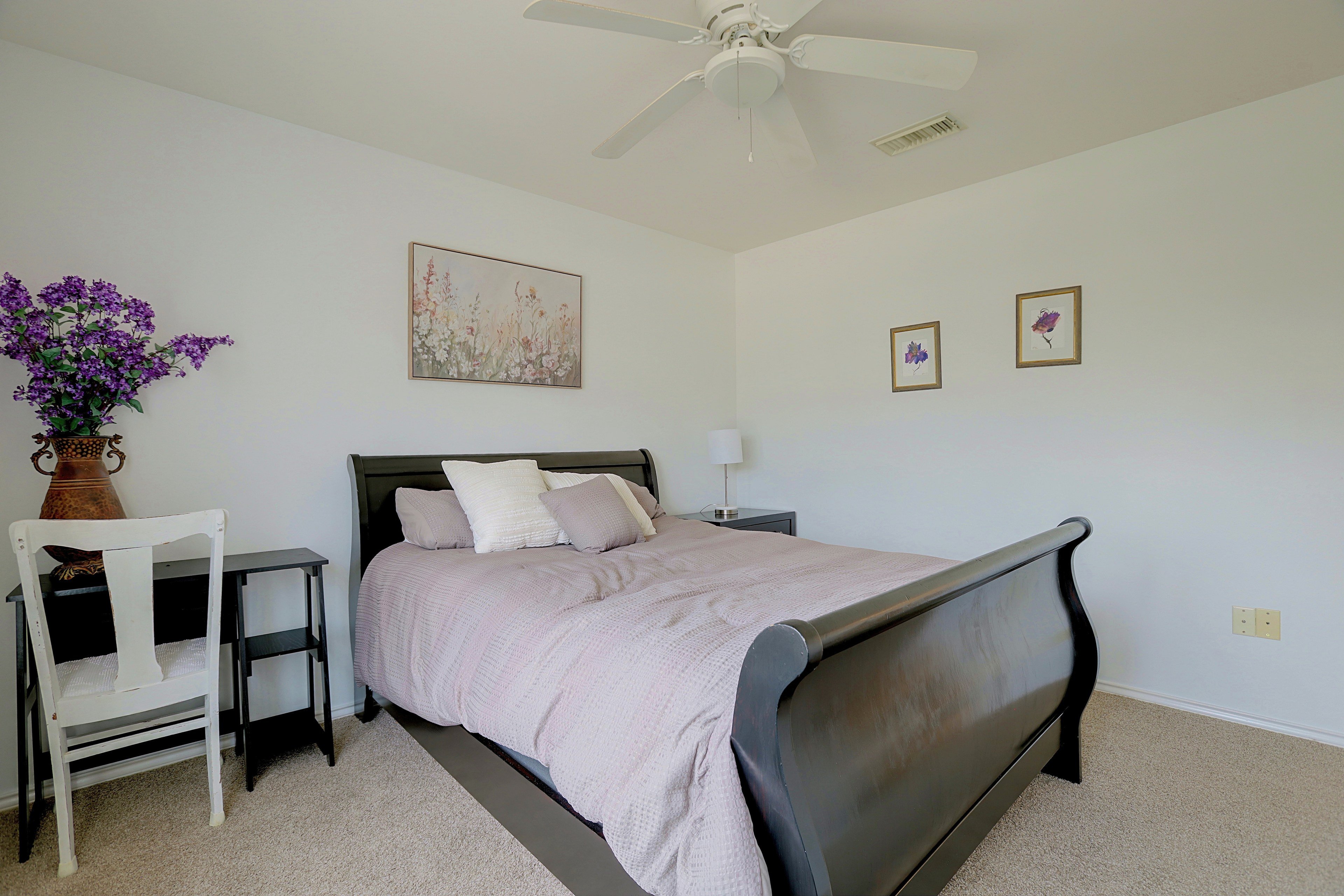 Guest bedroom view with sleigh bed and desk area.