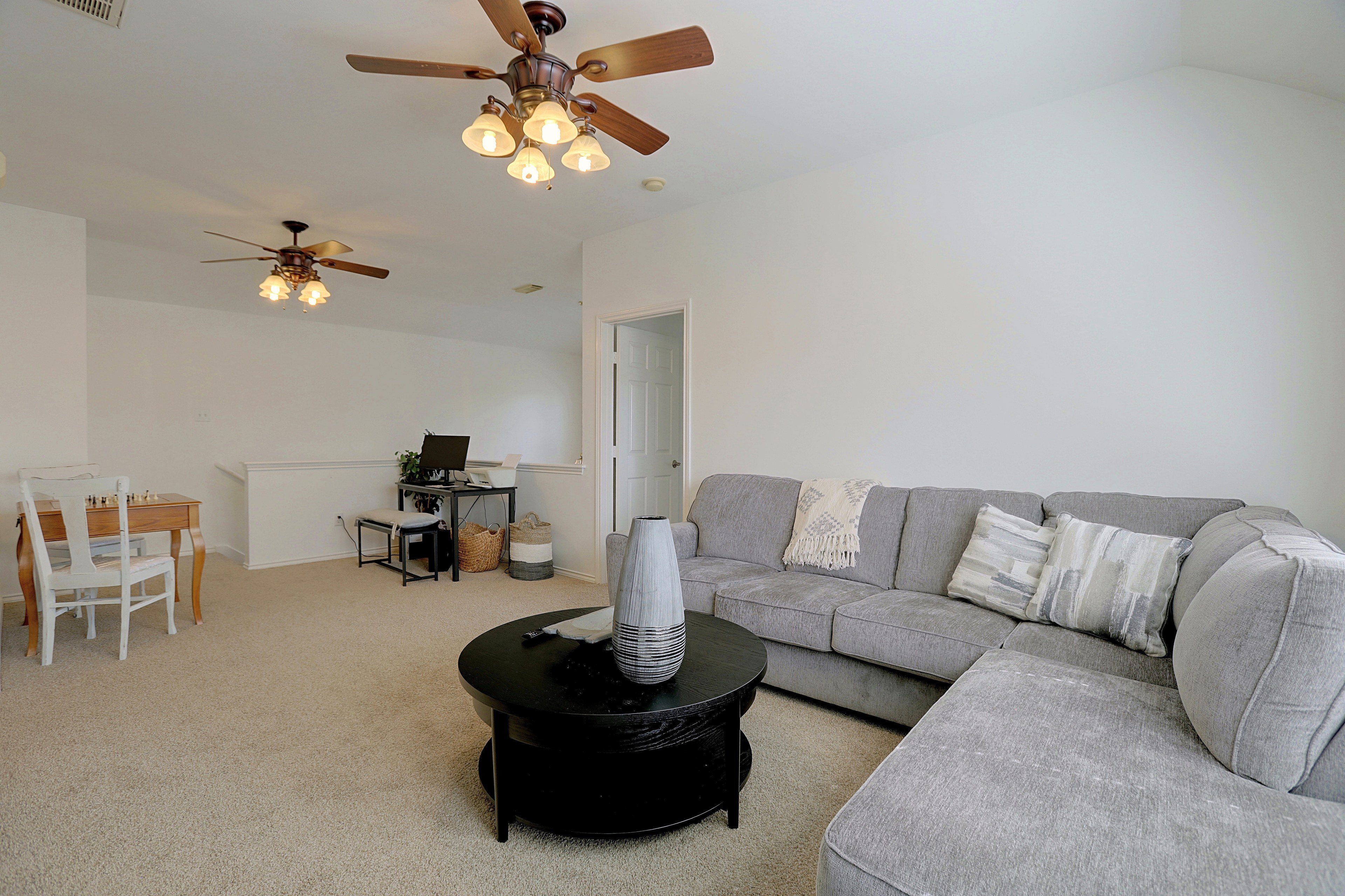 Overview of upstairs loft with couch, coffee table, and study corner.