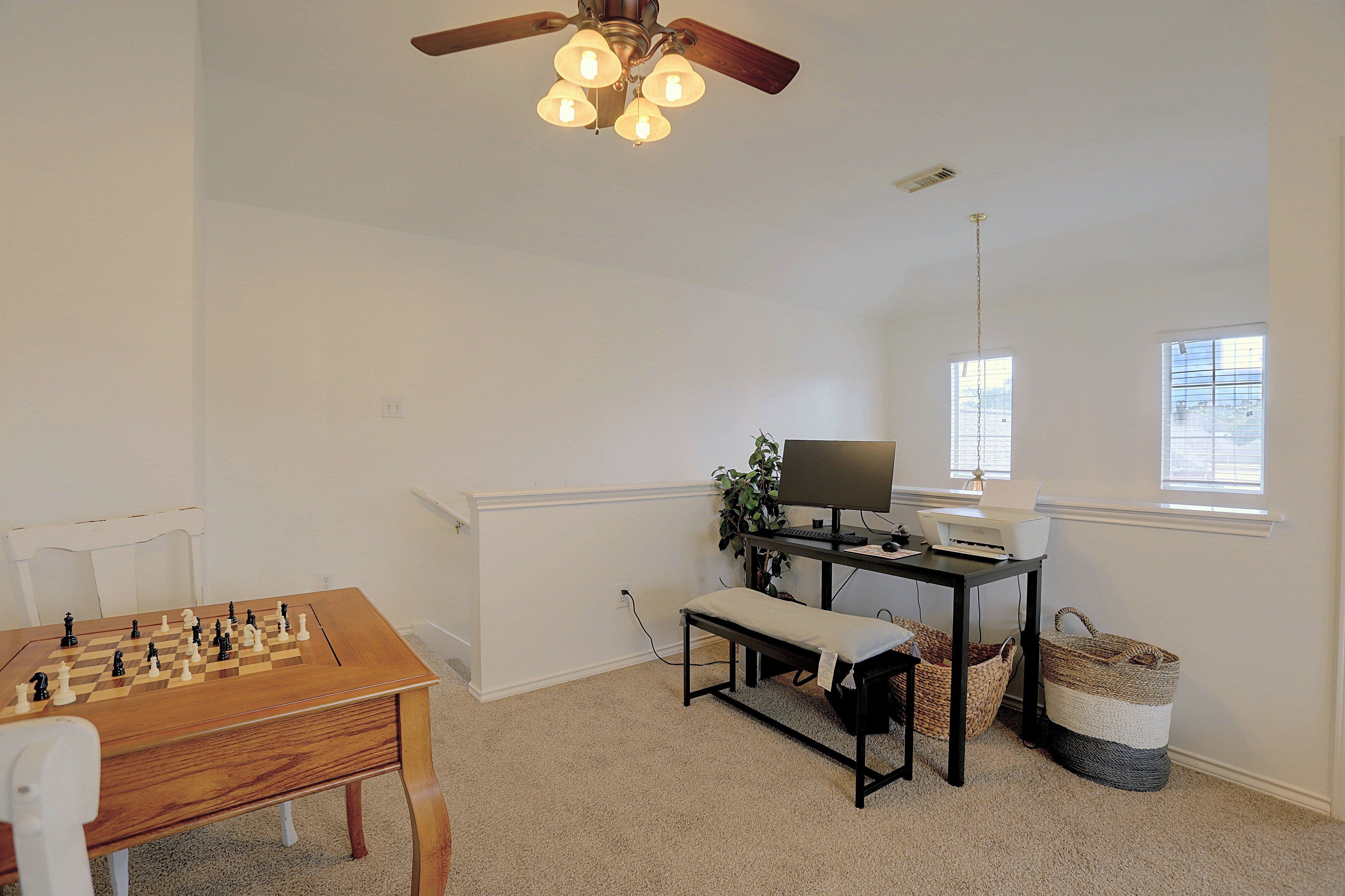 Desk setup in loft space with computer monitor and printer.