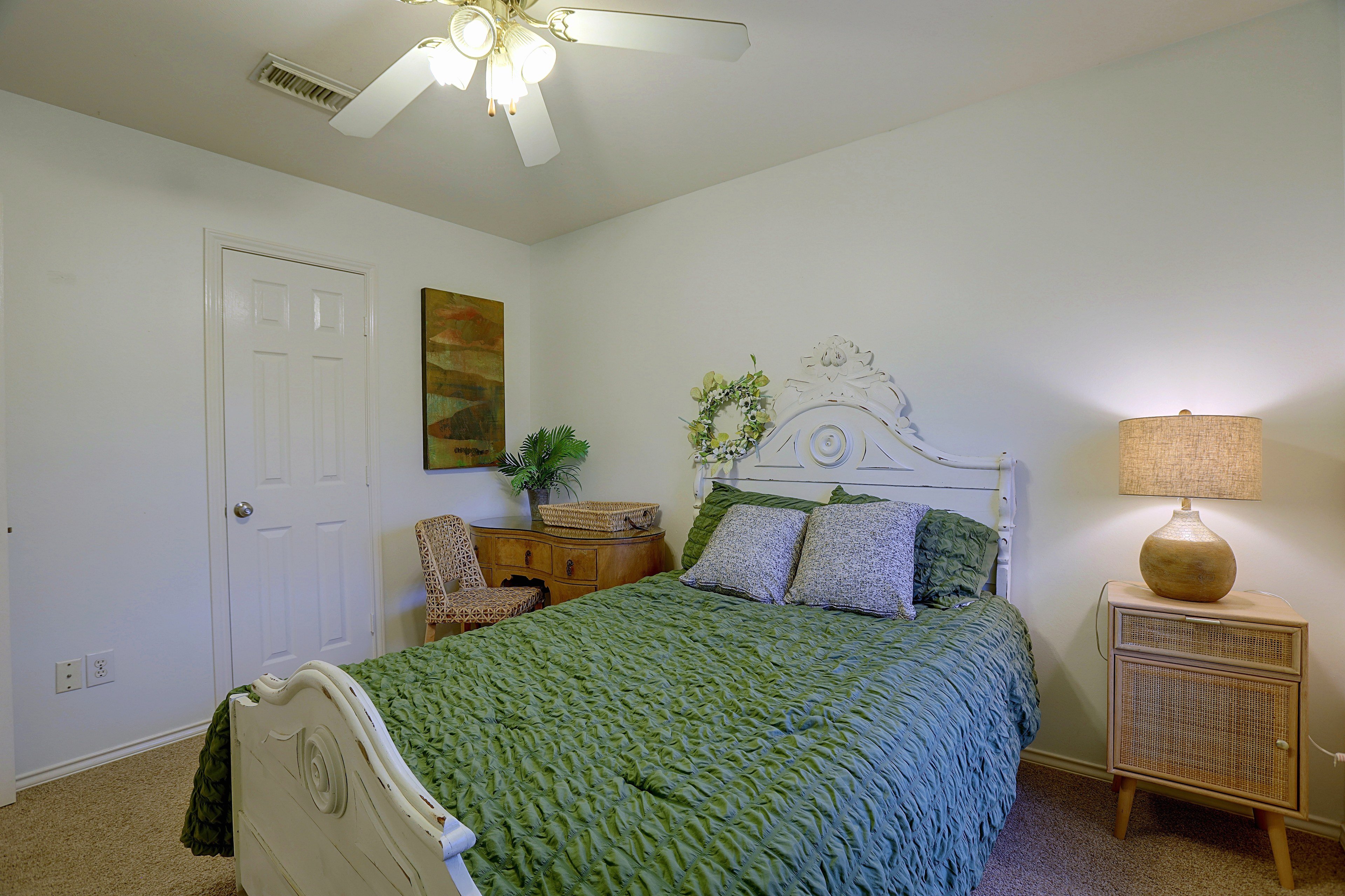 Guest bedroom view looking toward interior door and artwork.