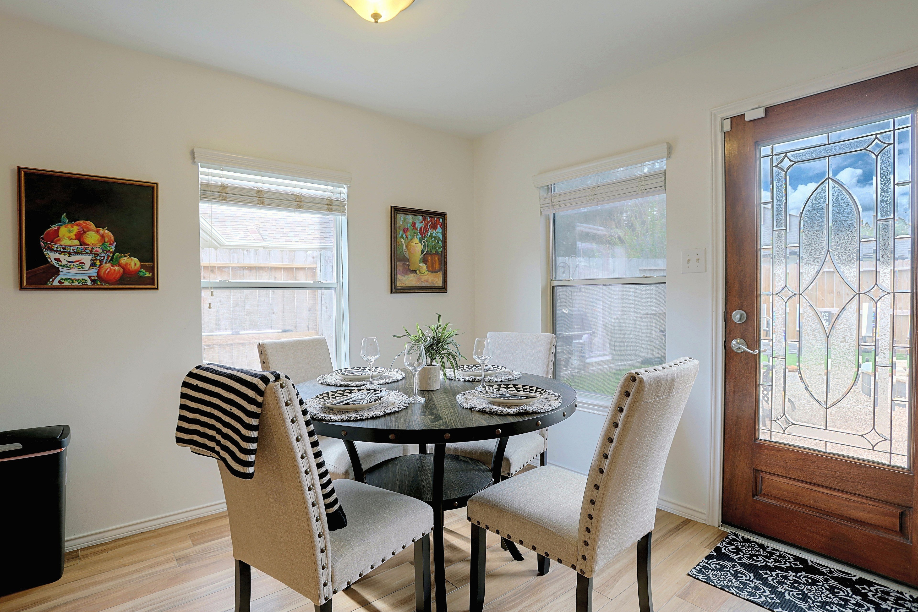 Dining nook off the kitchen with seating for four and glass door access to the backyard.