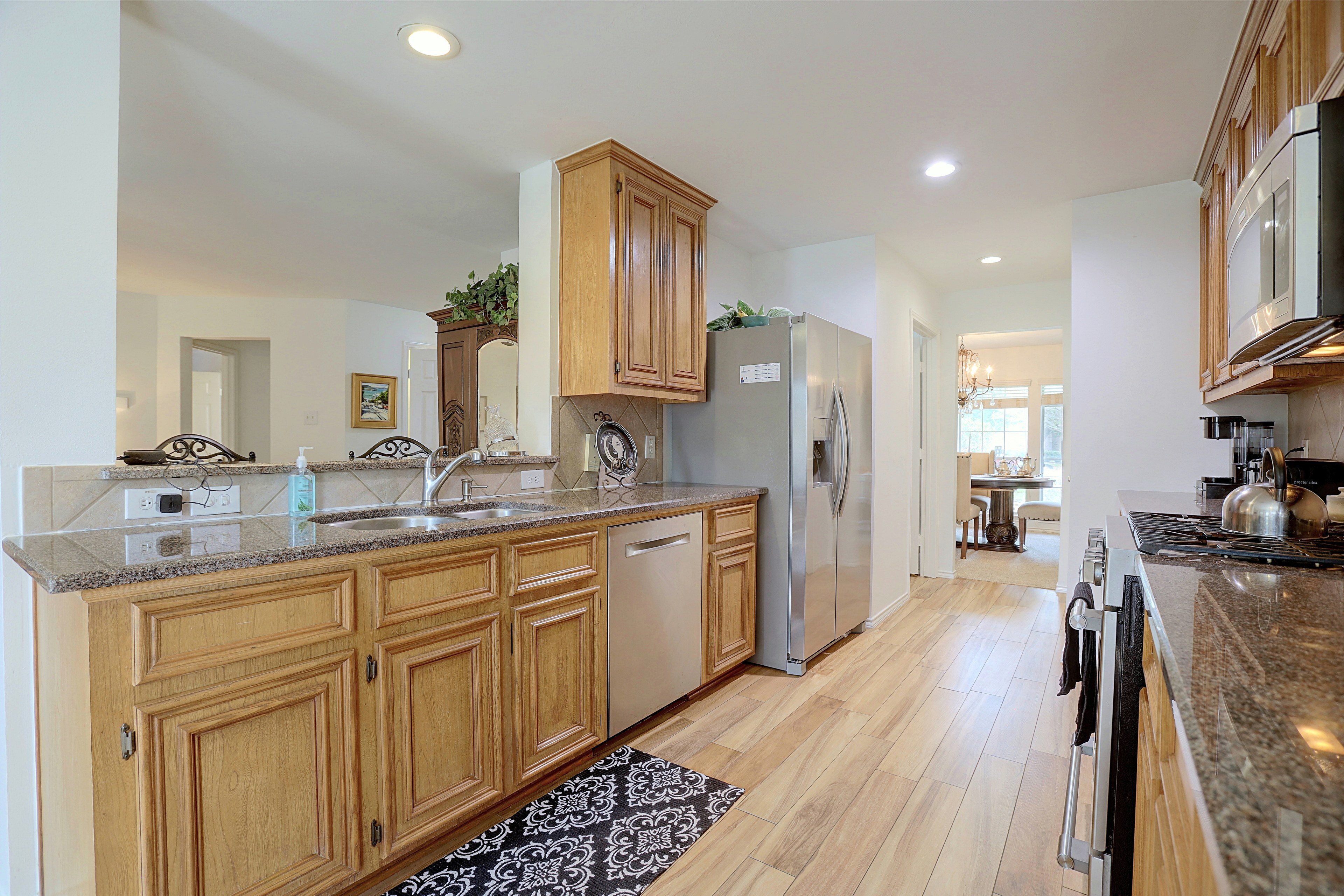 Kitchen view showing oak cabinets, granite countertops, and dishwasher.