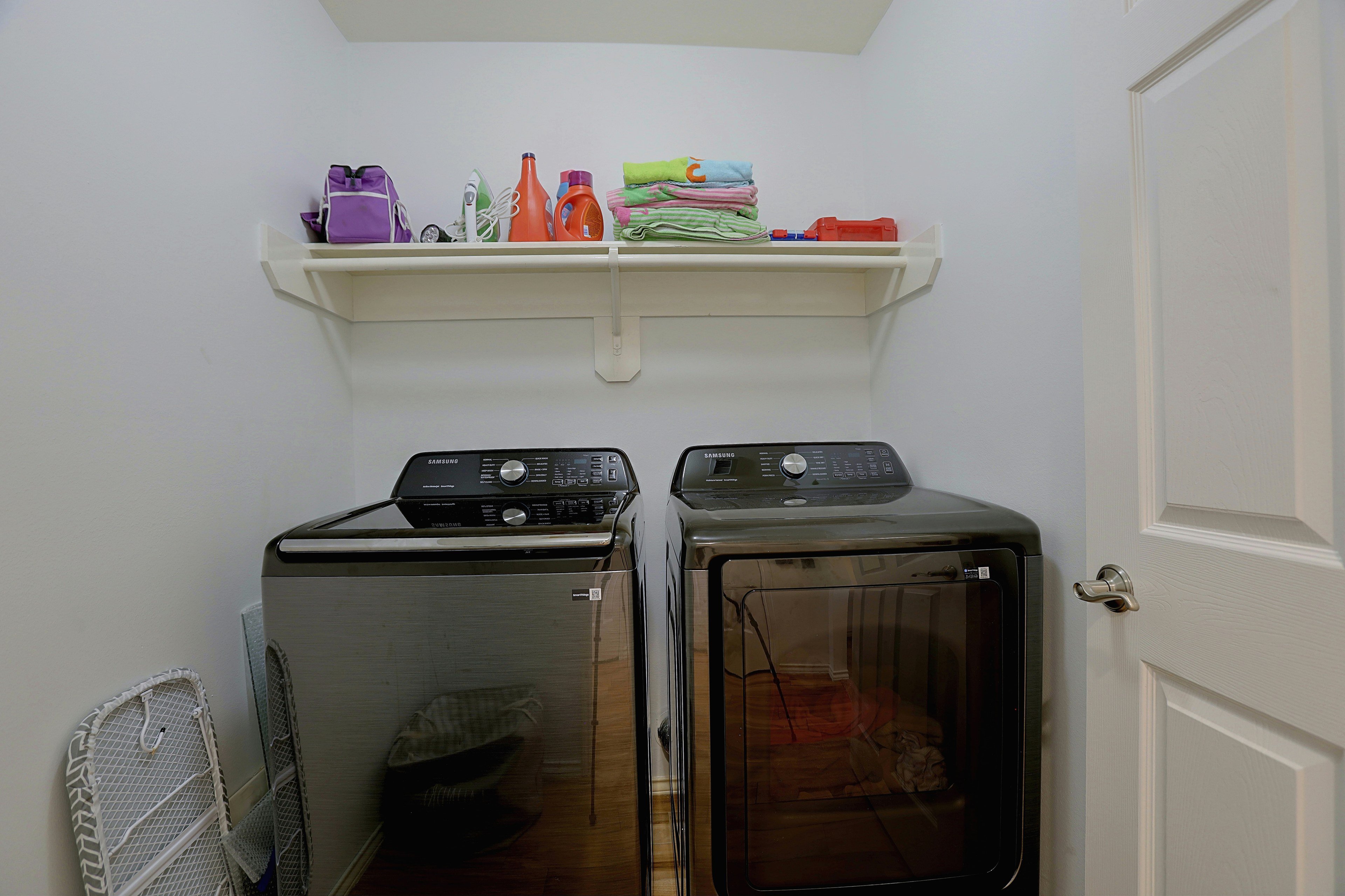 Dedicated laundry room equipped with a washer, dryer, and storage shelving.