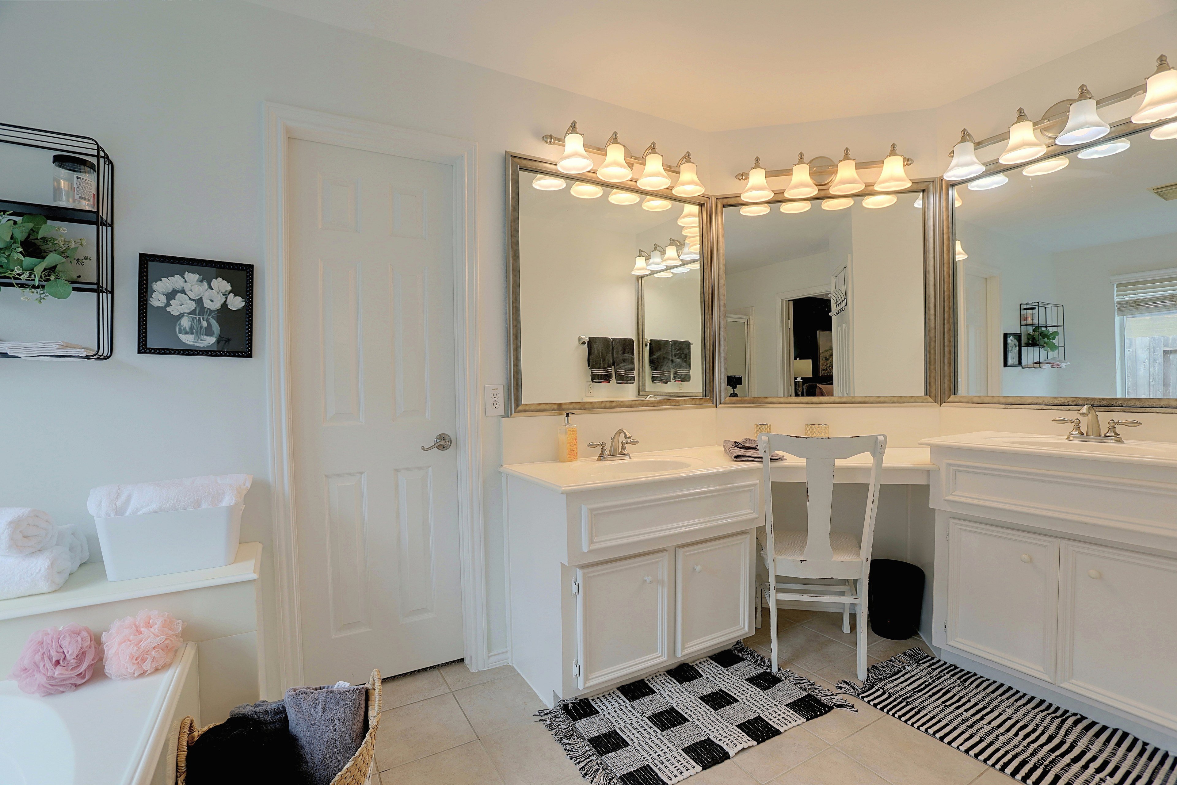 Primary bathroom double vanity with broad mirrors and a built-in makeup vanity area.