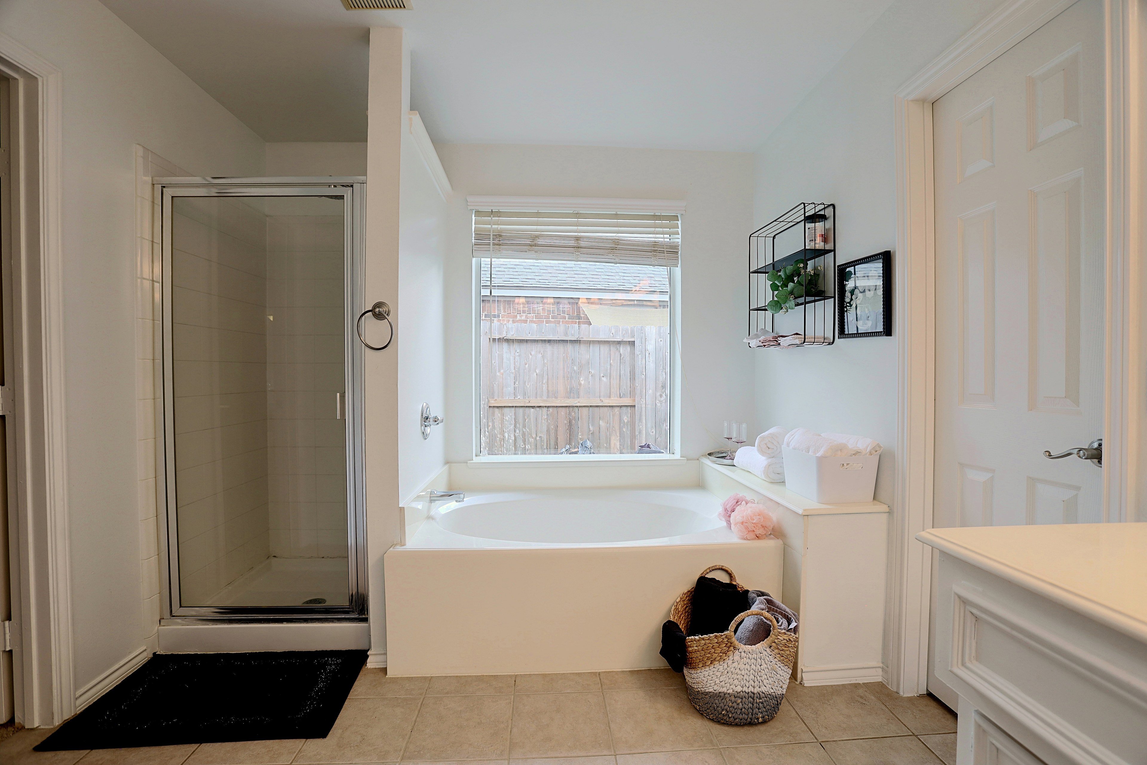 Primary bathroom featuring a deep soaking tub, glass-enclosed walk-in shower, and tile flooring.